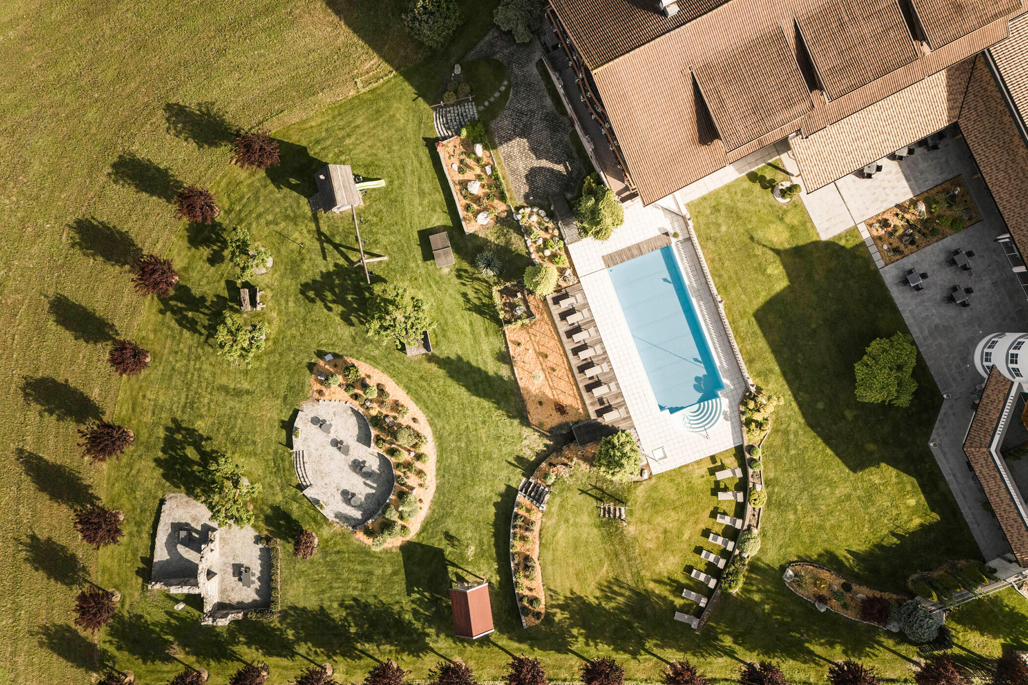 Vista a volo d'uccello sul prato e sull'area prendisole intorno all'hotel