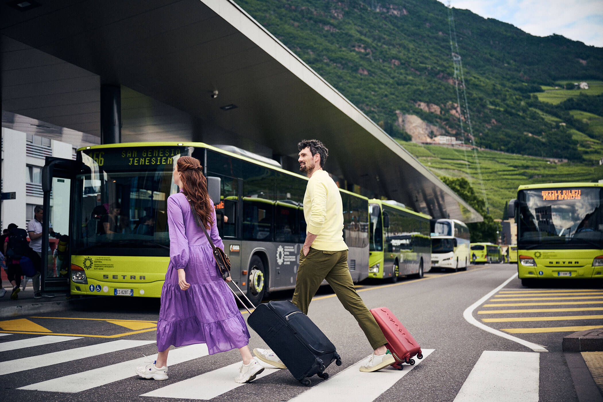 Ein Paar mit Koffern beim Busbahnhof