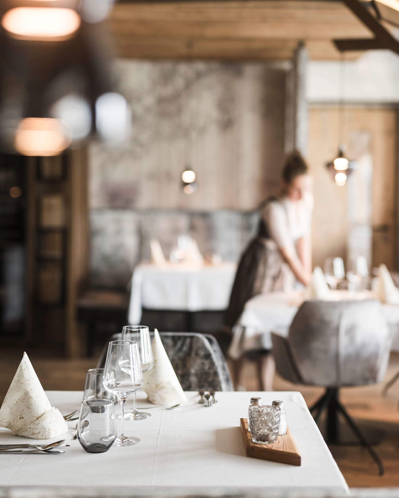 Die Gastgeberin deckt die Tische im Speisesaal