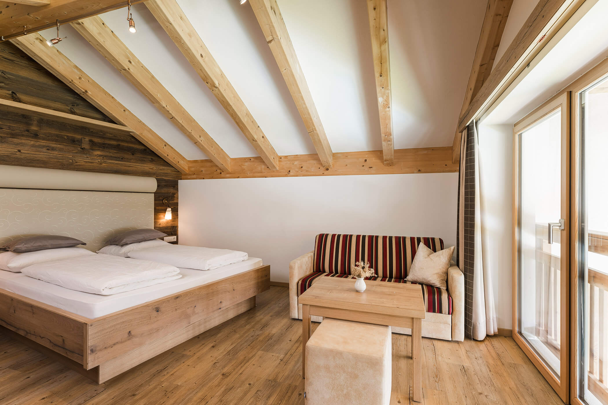 Letto matrimoniale e divano nella Alpine suite